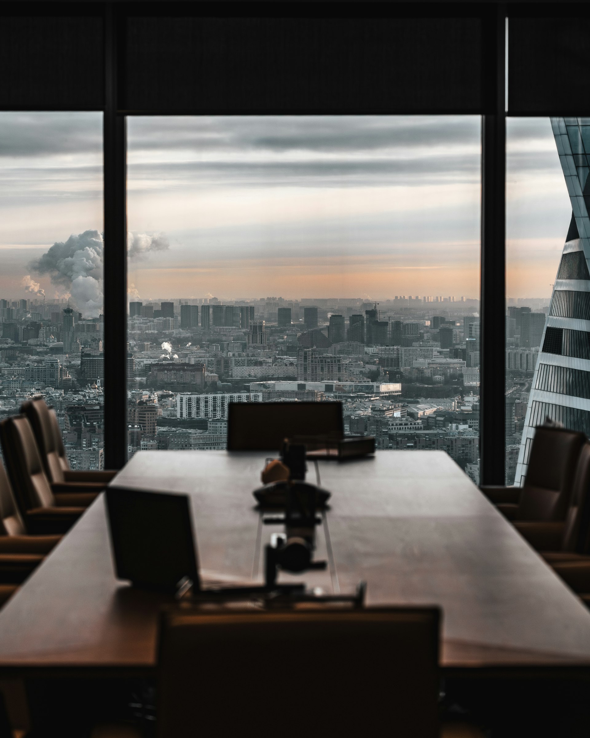 Leerer Konferenzraum mit Blick über die Stadt in der Abenddämmerung
