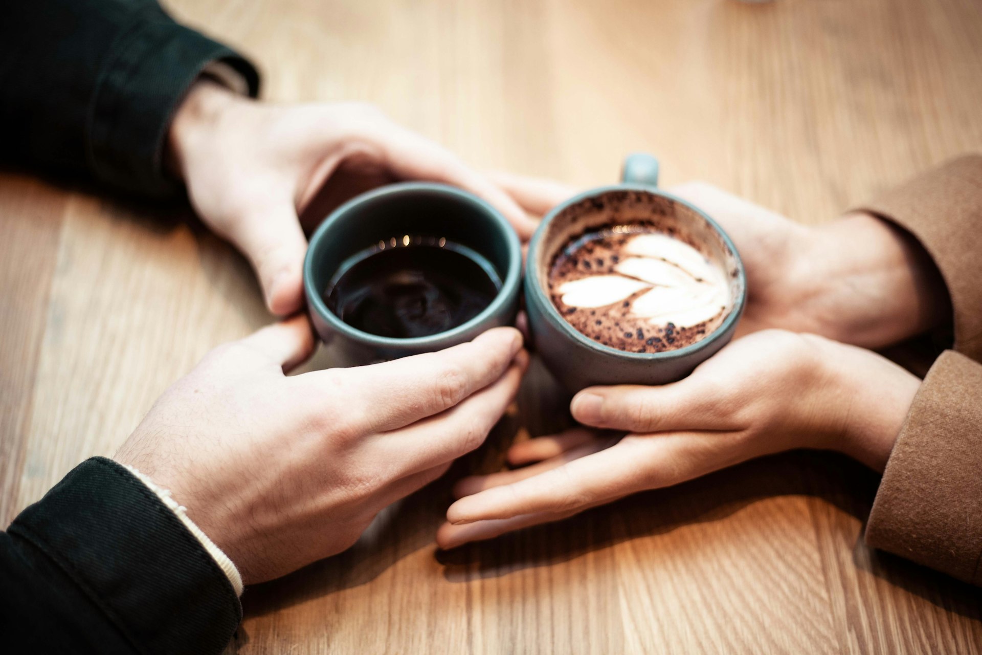 Zwei Gesprächspartner mit Kaffeetassen in einem ruhigen Gespräch