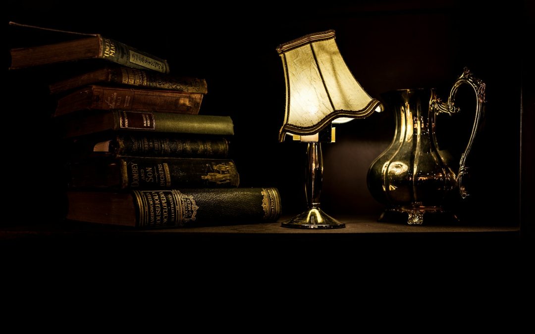 Bücherstapel neben einer Schreibtischlampe